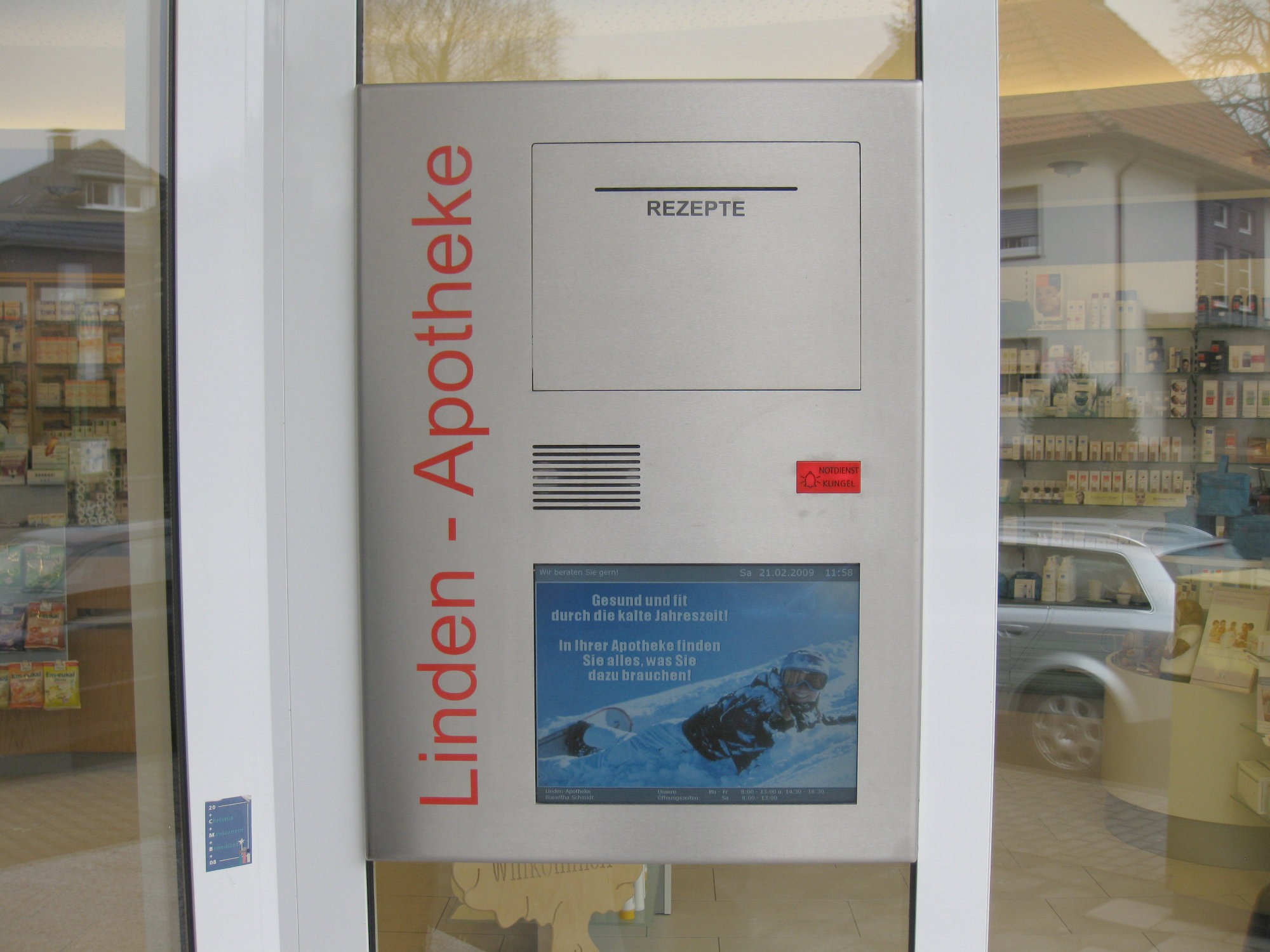 Eine DACOS Notdienstanlage mit Rezepteinwurf und Anzeigemonitor individuell in das Apothekenschaufenster neben der Eingangstür eingesetzt.
